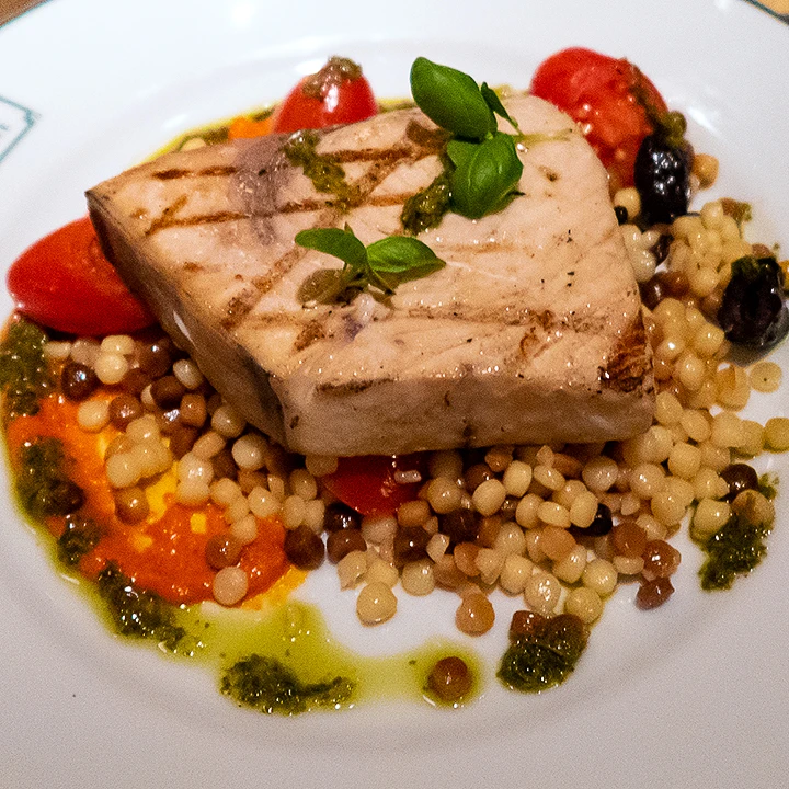 Swordfish with tomatoes, olives, pesto and giant couscous